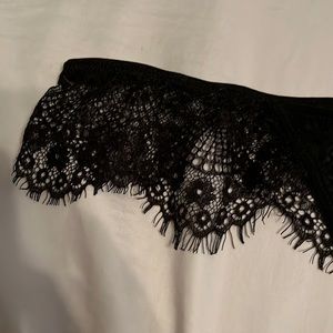 Mostly black lace, sheer coverage to front area. Thin thong area.